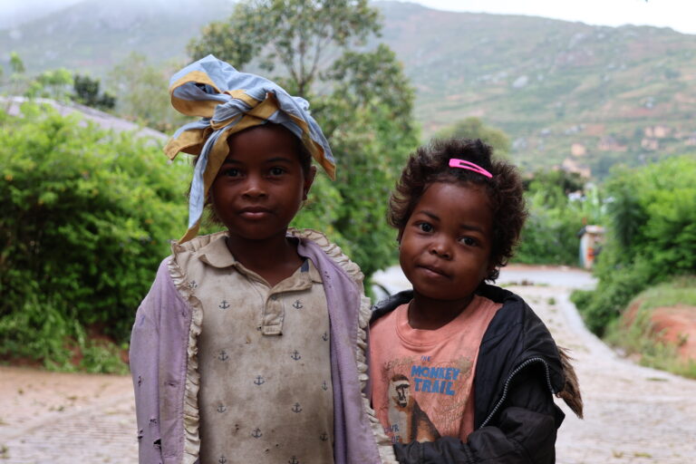 Deux petites filles malgaches souriantes regardant la caméra.